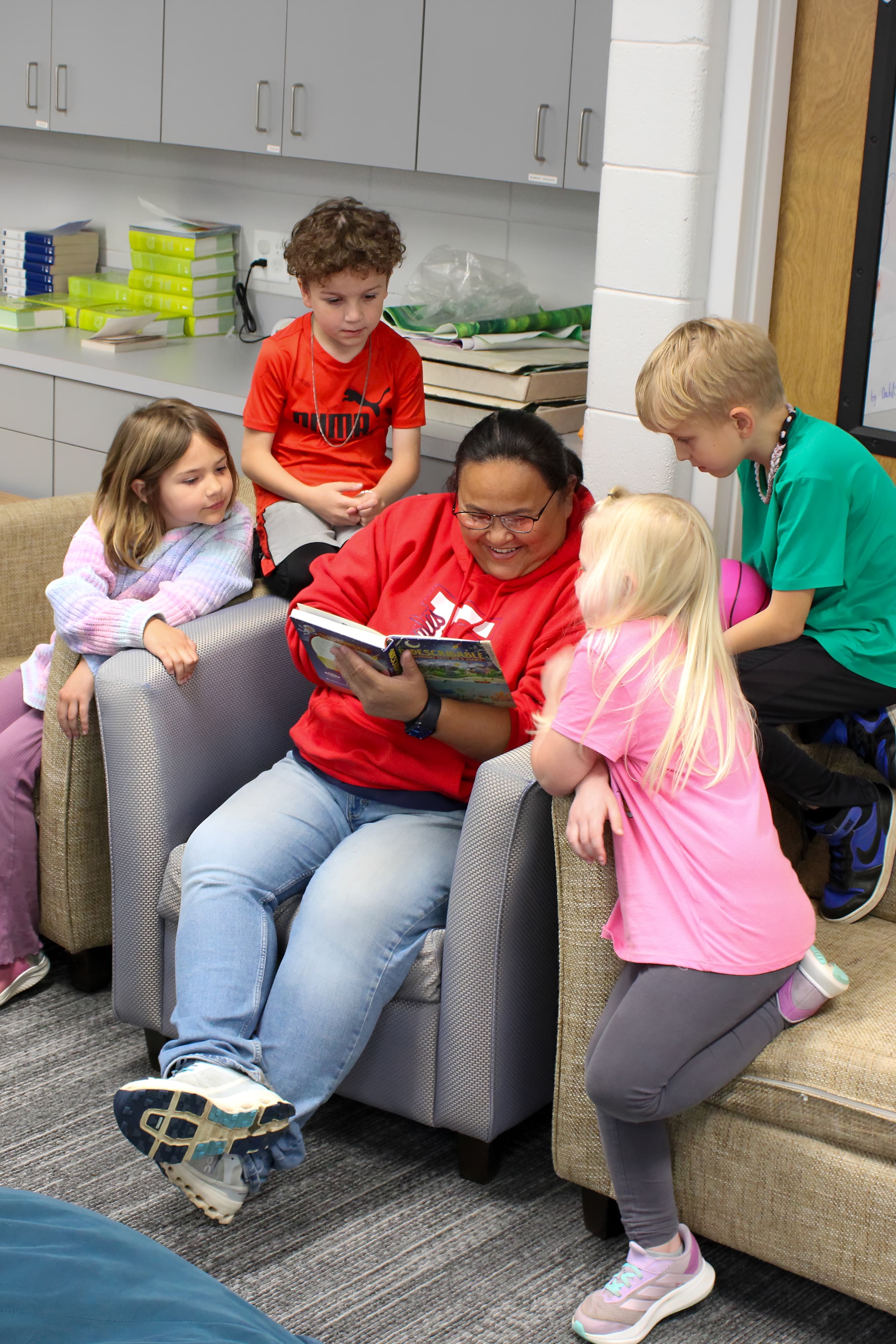 Older children gathered around a story being read aloud